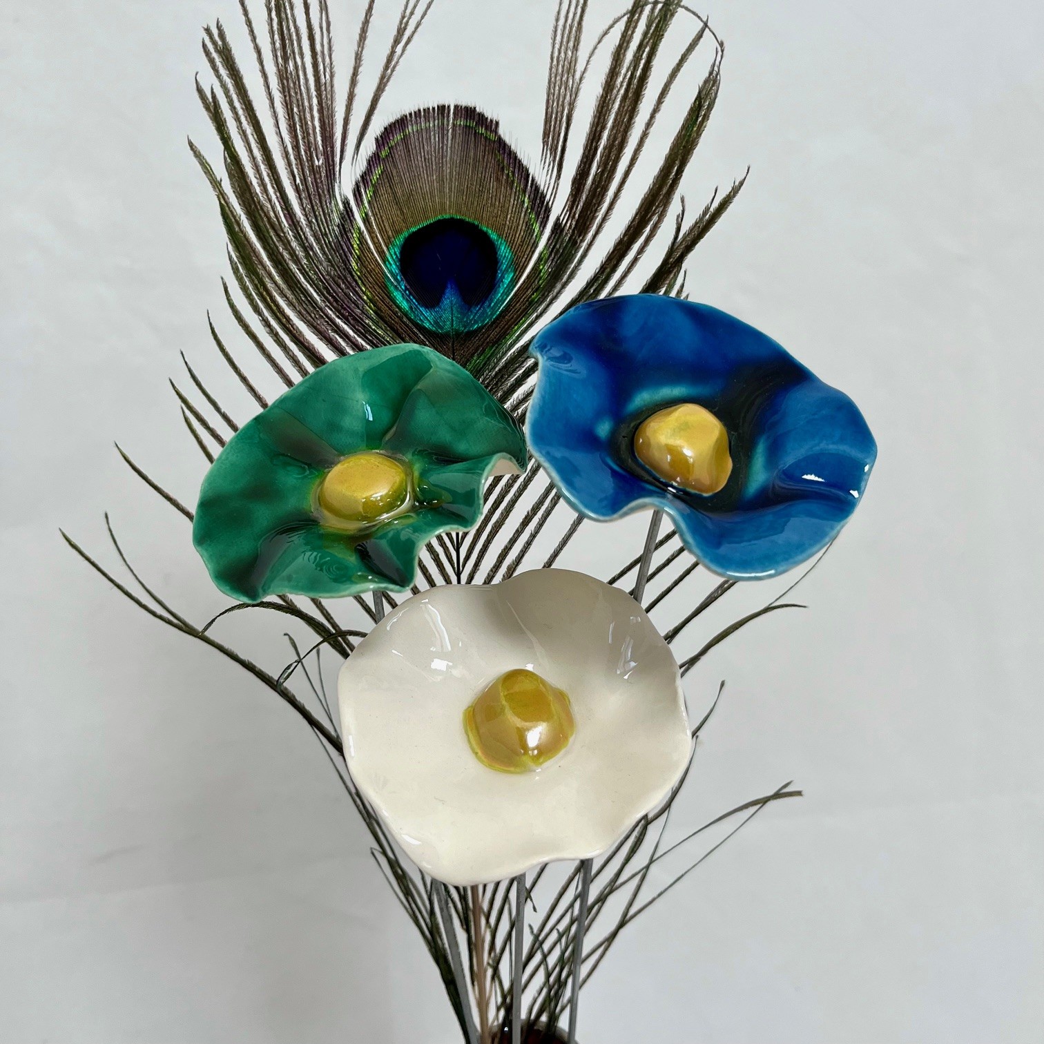 3 coquelicots vert émeraude, bleu nuit, blanc et plume de paon Hauteur 35 cm